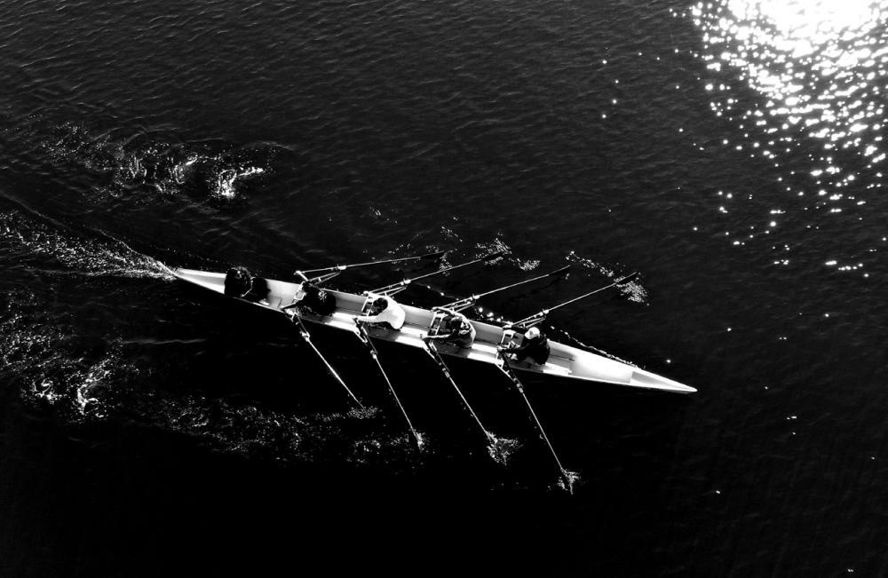 rowers on lake black and white